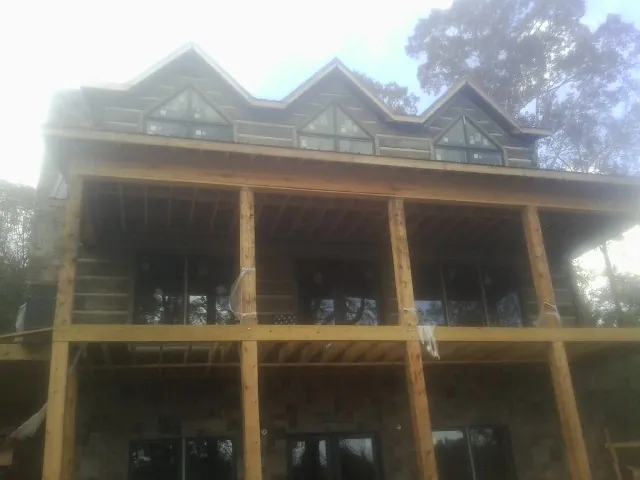 Dormers and porch framing on a large log home under construction — Roof Coating work by our crew in Montana Mines