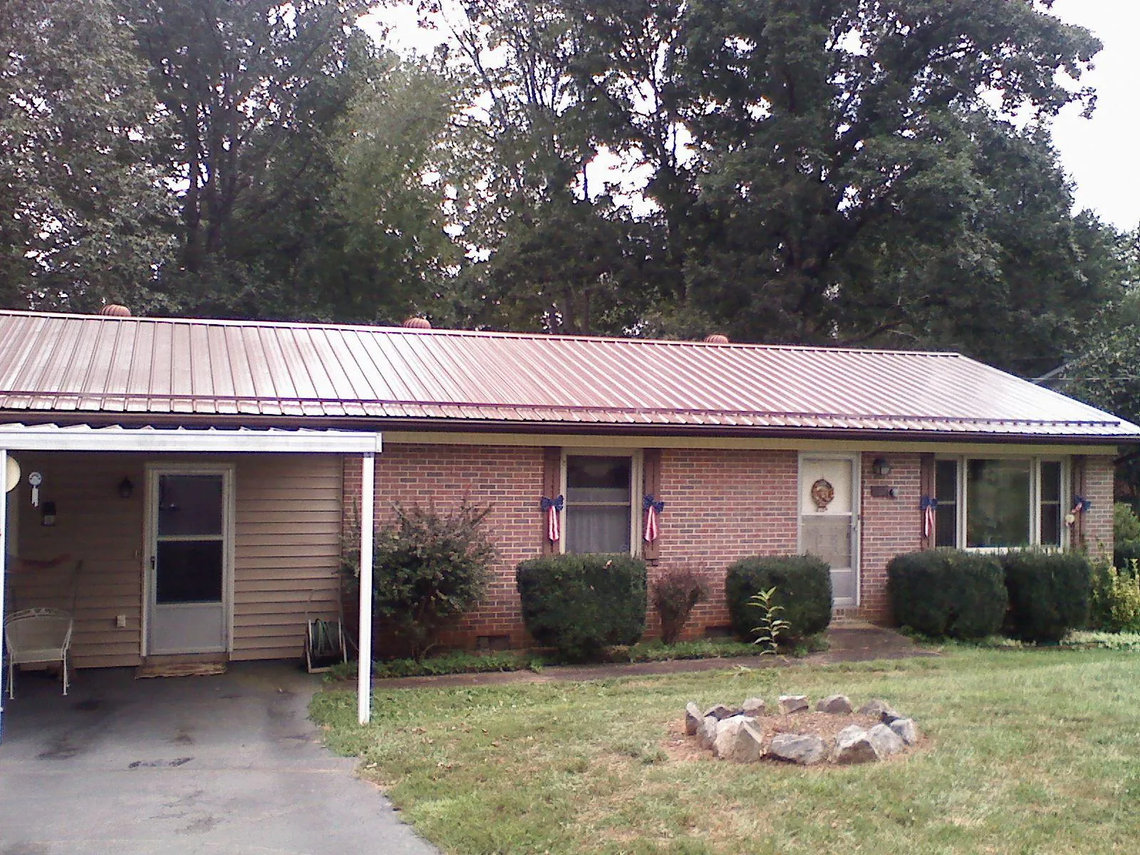 Bronze metal roof and carport on a brick ranch home — Roof Repair work by our crew in Montana Mines